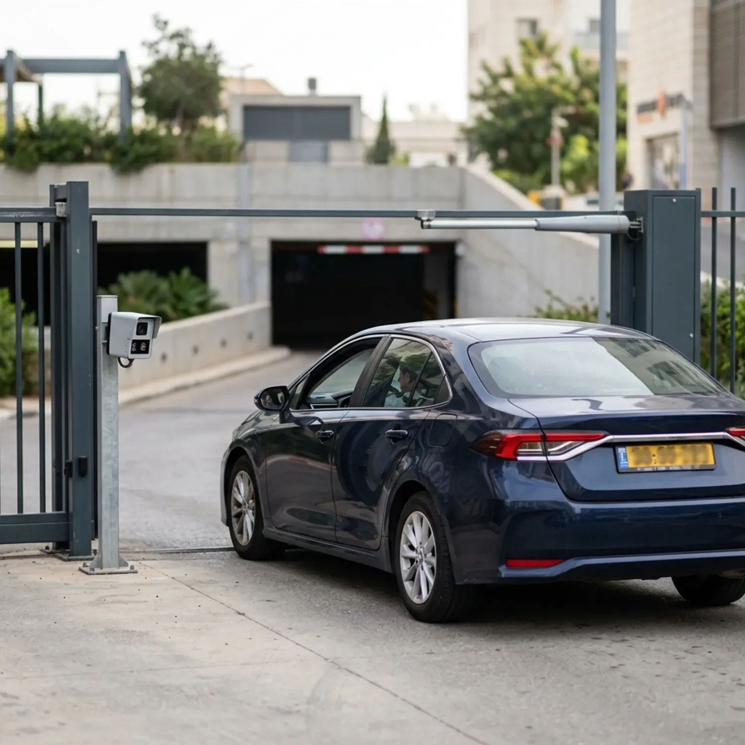 צילום של רכב הממתין מול שער חשמלי בחניון מסחרי, כאשר חיישן מצלמת LPR קורא את לוחית הרישוי, תאורה יומית